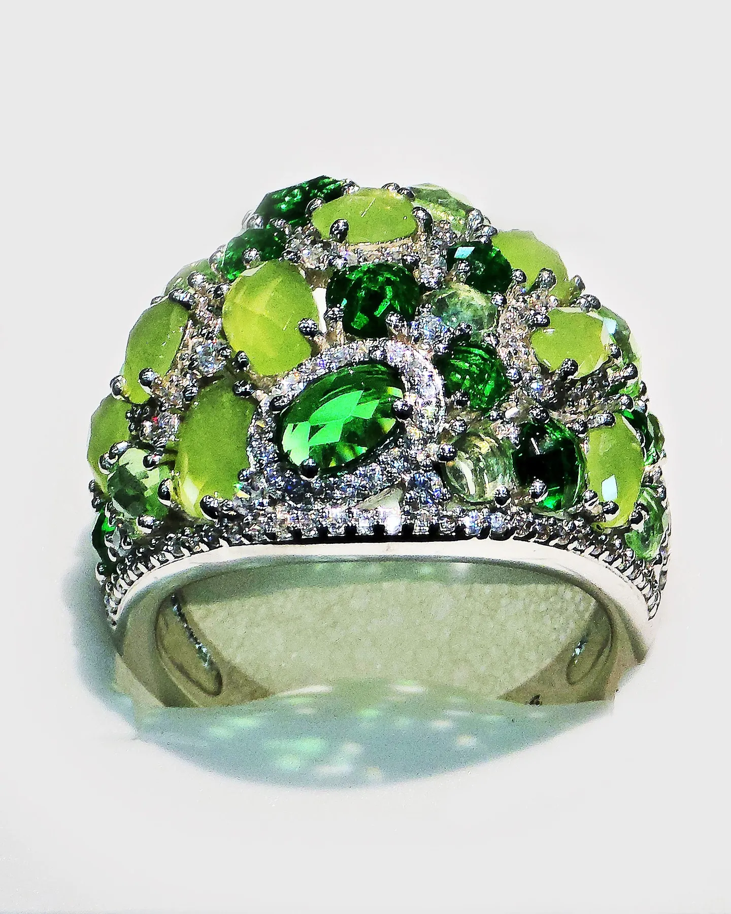 Silver cocktail ring set with green stones in many shades
