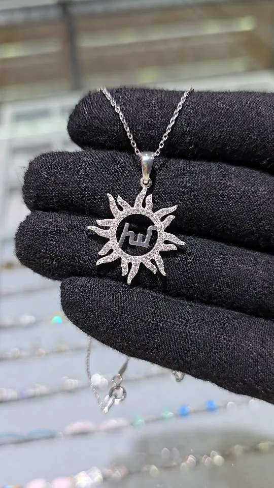 Silver sun pendant with sparkling rays